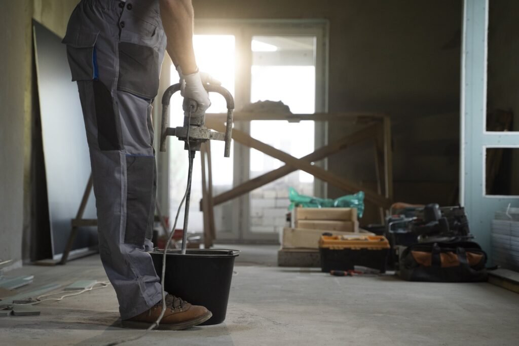 Renovation site in Philadelphia before a post construction cleaning, with tools, dust and bare concrete floor